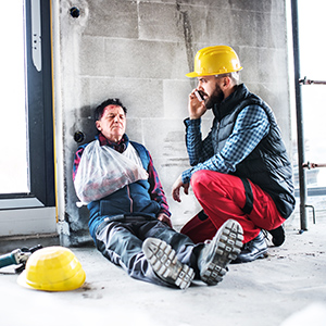 Construction worker with an arm injury on a phone, illustrating an injury at work and workers' compensation in Ohio